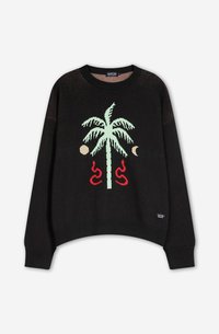 Svart strikket genser med grønt palme-design, røde slange-motiver og måne-acenter. Ribbestrikkede mansjetter og hem, avslappet passform.