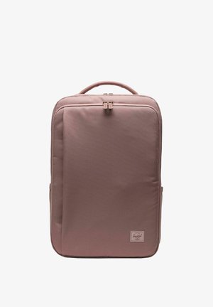 Sac à dos rectangulaire mauve avec poignée supérieure, poche zippée à l'avant et un petit écusson logo Herschel en bas à droite.
