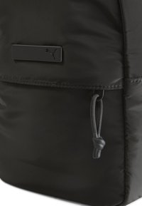 Rucsac negru din nailon cu un finisaj texturat, un buzunar cu fermoar dotat cu un cordon de tragere și o placă cu logo negru.
