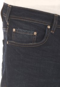 Jean en denim bleu foncé avec coutures dorées, doté d'une poche avant avec bouton et d'une passants de ceinture standard. Texture lisse visible.