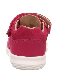 Kinderschuh aus pinkem Wildleder mit einer weißen Gummisohle, runder Zehenpartie und Klettverschluss. Verfügt über ein weiches Innenfutter und gestickte Akzente.