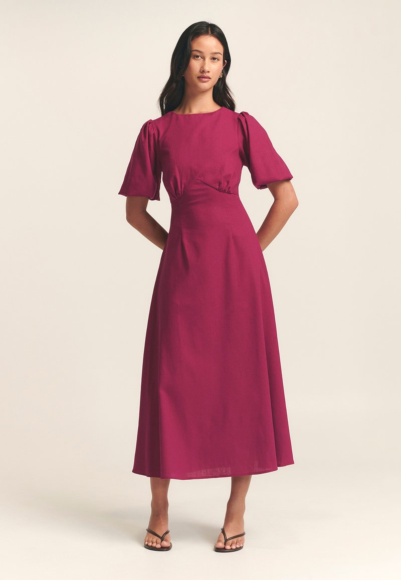 Fuksia midi-mekko puffihihnoilla, kapealla vyötäröllä ja sileällä pinnalla. Ominaisuuksiin kuuluu yksinkertainen pyöreä pääntie ja virtaava hame.