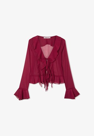 Blusa bordeaux con maniche lunghe, scollo e orlo arricciati, chiusura con lacci frontale e polsini svasati. Realizzata in tessuto leggero e trasparente.