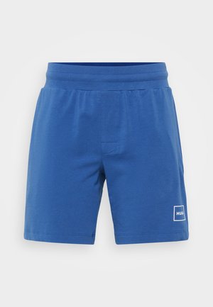 Shorts en coton bleus avec une taille élastique, présentant un petit patch logo blanc sur le bas droit et une coupe droite.