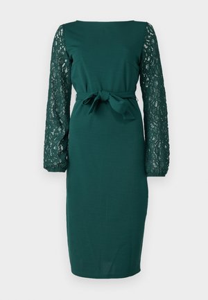 Groene jurk met lange kantmouwen, aangesloten silhouet, ronde halslijn en een strikdetail in de taille. Gladde stof met gemêleerde kantaccenten.