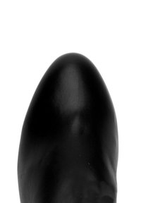 Zwarte leren schoen met een gladde, glanzende afwerking, spitse neus en een slank ontwerp, dat de naadloze en gestroomlijnde vorm benadrukt.