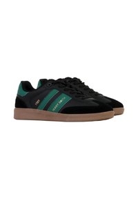 Des baskets noires et vertes présentent une tige en cuir lisse avec des accents en suede, des lacets plats et une semelle en caoutchouc beige. Les détails "Teddy Smith" et "1989" sont inclus.