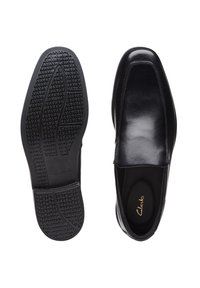 Schwarze Lederschuhe mit schlankem Design, elastischen Seitenpaneelen, strukturiertem Gummisohle und geprägtem Logo auf der Innensohle.