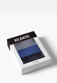 Zestaw trzech trunksów w pudełku. Kolory: granatowe z wzorem, jednolity niebieski oraz szary w kropki. Pudełko eksponuje produkt w sposób wyraźny.