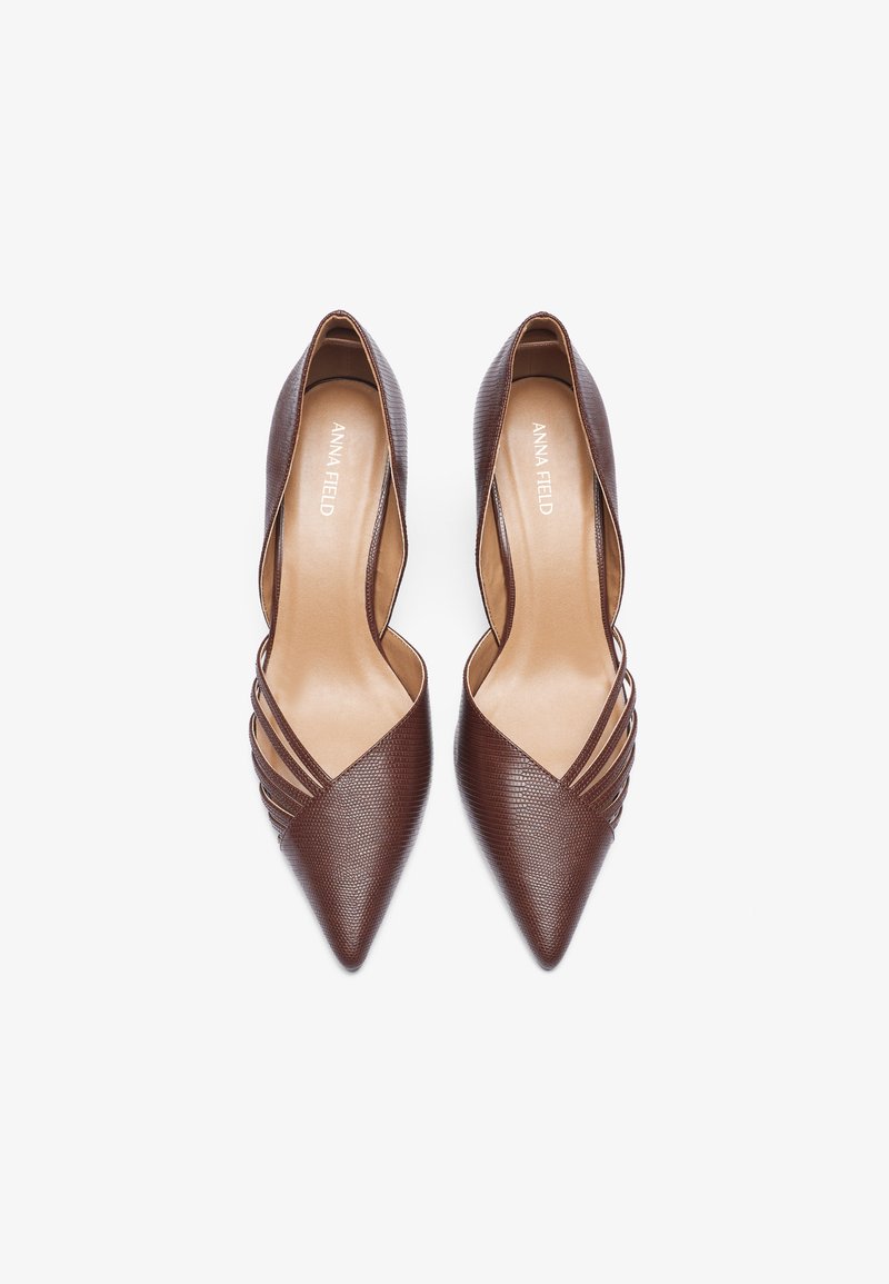 Zapatos de tacón alto de piel marrón con punta afilada, superficie texturizada y tres correas horizontales a cada lado. El interior presenta un forro suave de color beige.