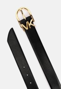 Cinturón de cuero sintético negro con acabado texturizado, que presenta una hebilla de metal en tono dorado y el logo "MK". Tres agujeros para ajustes de tamaño.