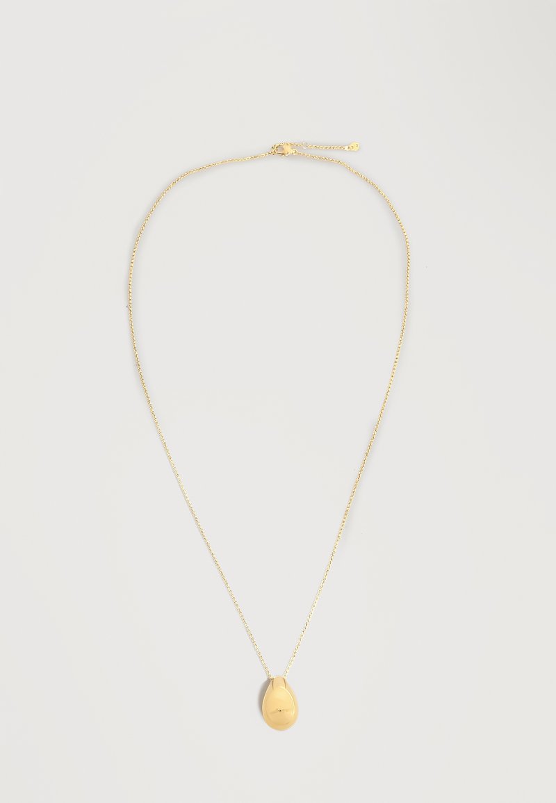 Λεπτό χρυσό κολιέ με αλυσίδα και λείος, γυαλιστερός μενταγιόν σε σχήμα σταγόνας, σε ανοιχτό ουδέτερο φόντο.