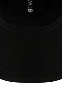 Schwarze Baseballkappe mit glatter Stoffoberfläche, gebogenem Schirm und einem Etikett mit der Aufschrift "9TWENTY", das innen im Kopfstück gestickt ist.