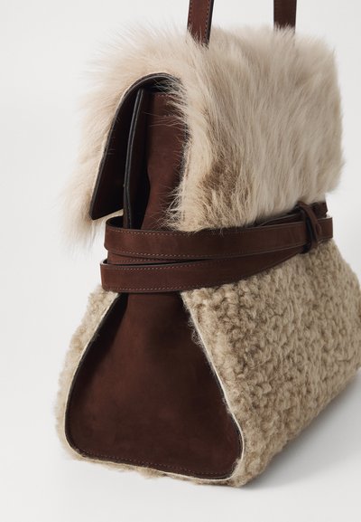 Sac à main en daim marron et en tissu texturé beige, avec un rabat supérieur en fourrure, présentant une forme structurée et une base large et plate.