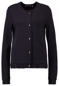 Marineblauwe cardigan met een ronde halslijn, drukknopen als sluiting en een geplooide onderrand. Gemaakt van een zachte, rekbare stof met lange mouwen.