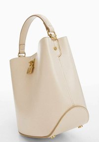 Borsa a secchiello in pelle beige con un manico singolo, hardware color oro e un piccolo lucchetto decorativo sul lato.