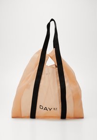 Peach mesh tote bag with black fabric straps and logo "DAY ET." Features a soft, semi-transparent texture and a triangular cutout at the top.