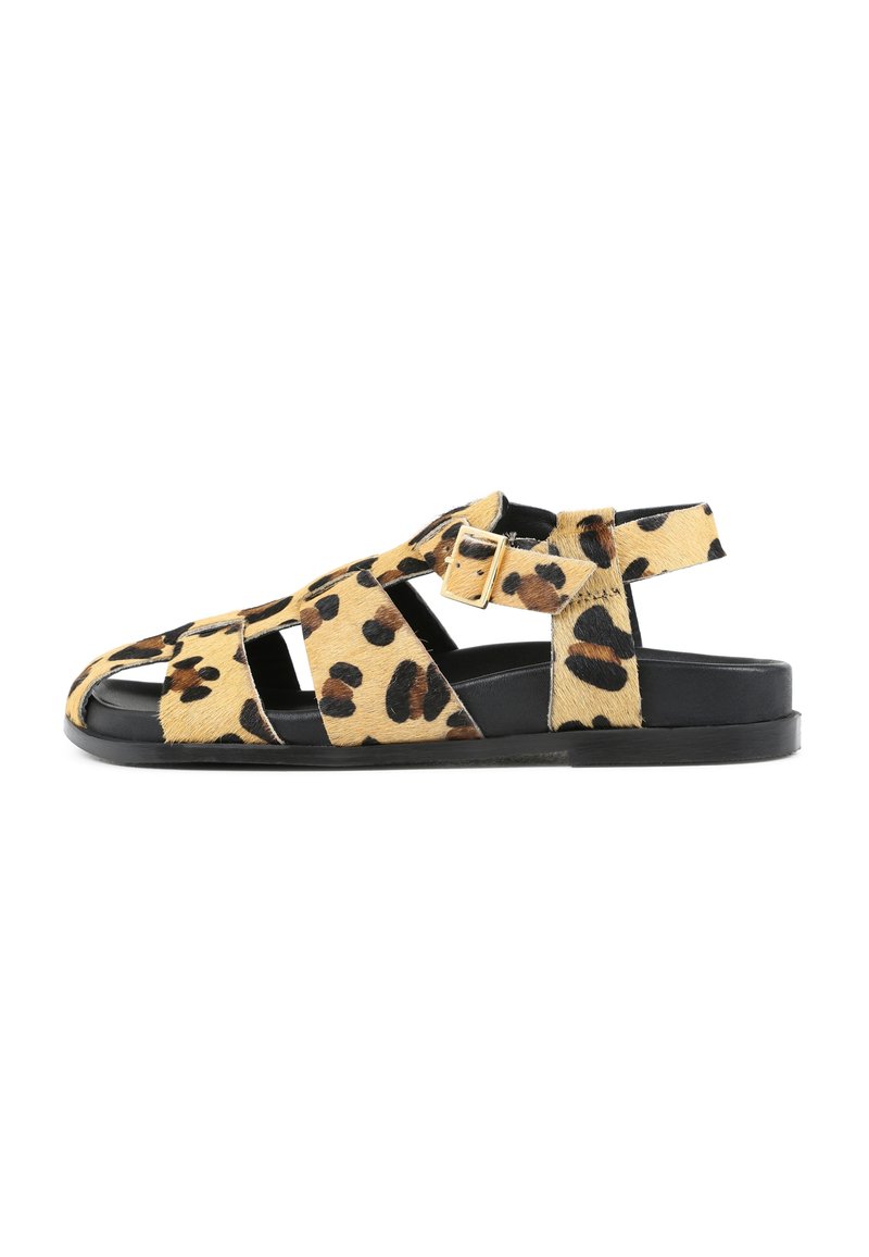 Sandalias de estampado de leopardo con suelas de goma negra, que presentan una correa y un cierre de hebilla, fabricadas con un material texturizado similar al pelo.