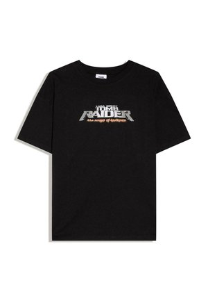 Tricou negru cu mâneci scurte, cu text argintiu și portocaliu „Lara Croft Tomb Raider the angel of darkness” pe piept.