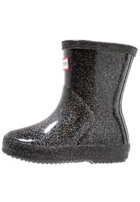 Bota de lluvia de goma negra con acabado brillante, que presenta destellos de purpurina plateada, una suela texturizada y un pequeño logo en el lateral.