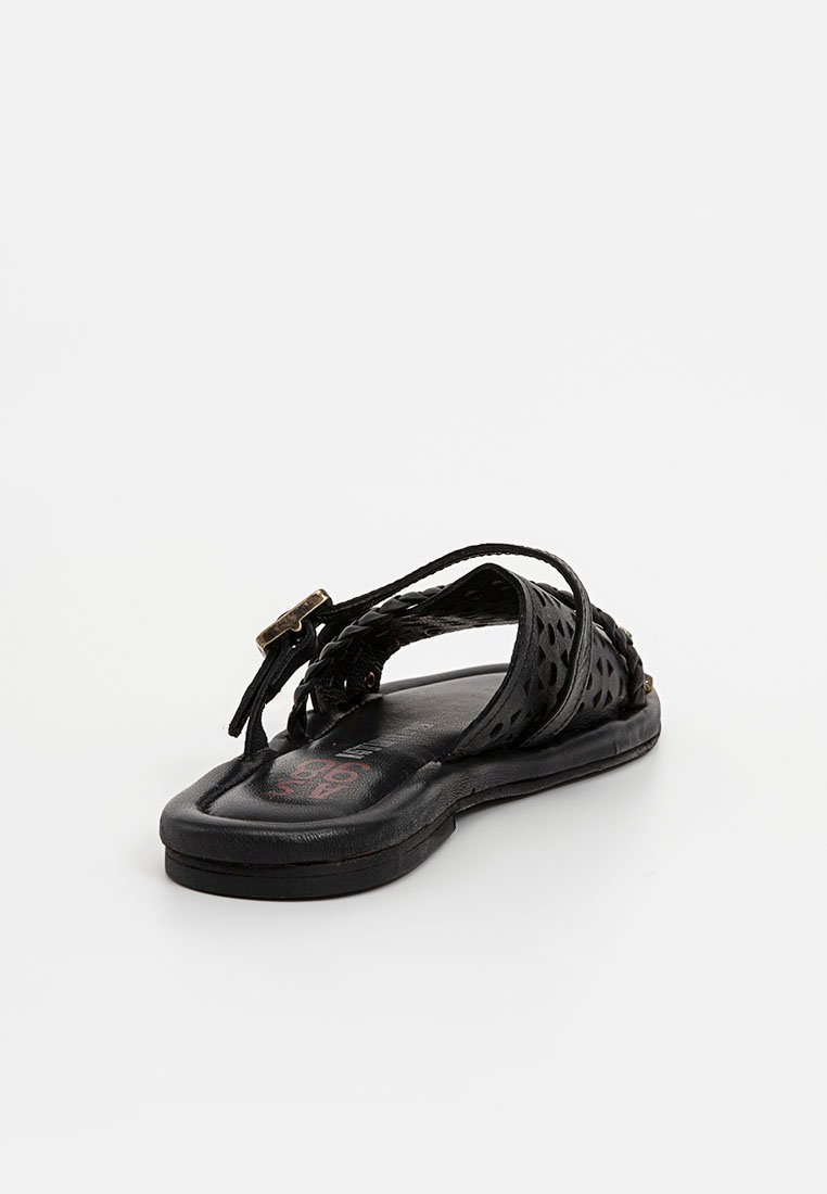 Schwarze flache Sandalen mit einem geflochtenen Design und Cut-Out-Mustern, aus Leder gefertigt und mit einem kleinen goldenen Schnallen-Detail am Riemen.