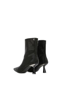 Čierne členkové čižmy s textúrovaným vzorom, s špicatou špičkou a zužujúcim sa podpätkom. Dizajn obsahuje jemný detail loga.