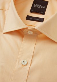 Ljust orange slim-fit skjorta i 2-lagers twill. Har en klassisk krage, knappstängning fram med en rund vit knapp och en subtil textur.