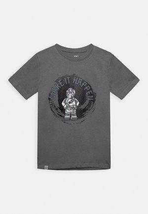 Mørkegrå T-shirt med korte ærmer med en LEGO ninja-figur og teksten "Make It Happen" i et cirkulært design på forsiden.