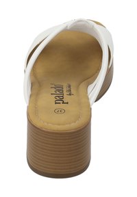 Sandale plateforme blanche avec de larges brides, un talon marron texturé et une semelle intérieure lisse ornée du logo de la marque en relief.