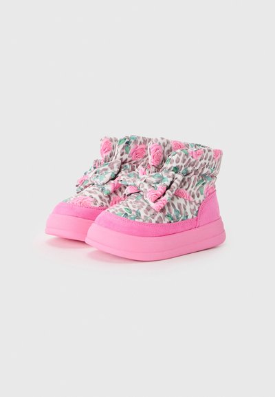 Des chaussures roses avec un dessus en tissu à imprimé floral et léopard, présentant de grands nœuds roses et un détail en suède texturé au niveau des orteils et de la cheville.