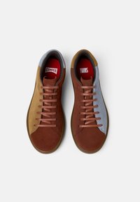 Brown and gray suede sneakers with rubber soles, featuring brown laces, contrasting textures, and red interior branding labels.