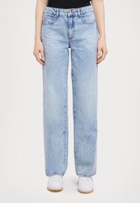 Jeans a gamba larga in denim azzurro chiaro con vita alta, caratterizzati da cuciture rosse, due tasche frontali e chiusura con zip.