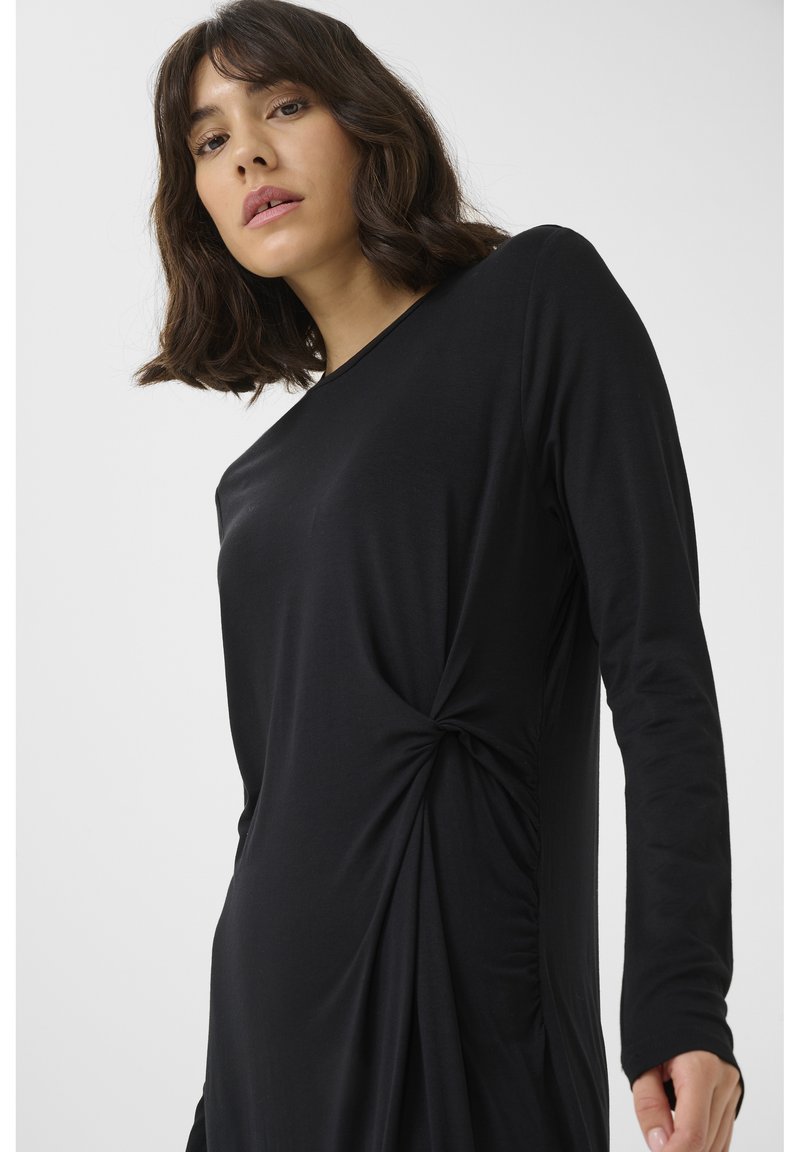 Black long-sleeve dress featuring a twisted knot detail on the side, made from soft, smooth fabric with a relaxed fit.