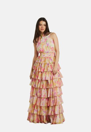 Lungo abito a strati realizzato in tessuto leggero. Presenta un motivo floreale colorato in rosa e giallo, con collo halter e una cintura in vita.