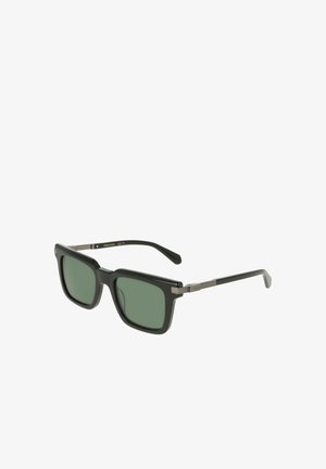 Lunettes de soleil rectangulaires noires avec verres verts et branches accentuées de métal, placées en angle sur un fond blanc.