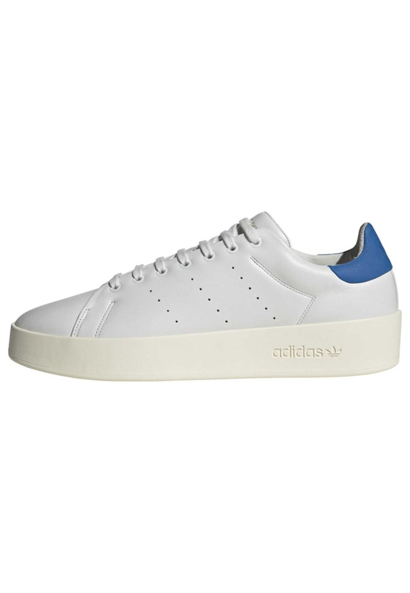 Vit lädersneaker med en enfärgad blå hälaccent, texturerad sida, perforerade detaljer och en tjock krämfärgad sula. "adidas"-logotypen är präglad.