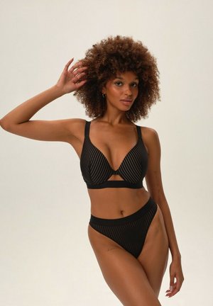 Czarny bikini w paski z głębokim dekoltem i szerokimi ramiączkami. Dół ma wysoki krój, co podkreśla całość.