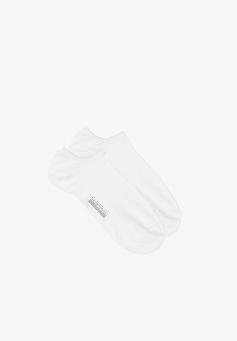 Weiße, knöchellange Socken aus einer weichen Baumwollmischung, die eine glatte Textur besitzen und ein kleines graues Markenlabel auf einer Seite haben.