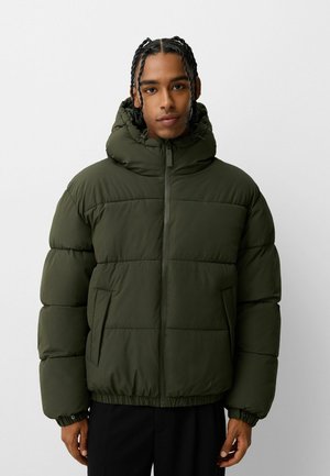 Giubbotto imbottito verde con cappuccio, dotato di zip frontale, polsi elastici e tasche laterali. Design imbottito per isolamento termico.