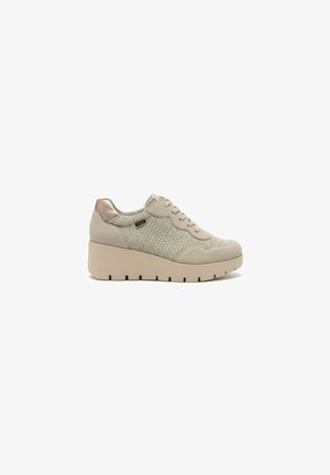Beige sleehaksneaker met gebreide zijkanten, veters aan de voorkant en een dikke, textuurrijke zool, zijaanzicht op witte achtergrond.