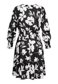 Vestido negro con estampado floral blanco, mangas largas, puños fruncidos y cintura ajustada con lazo, con un corte relajado y tejido suave.