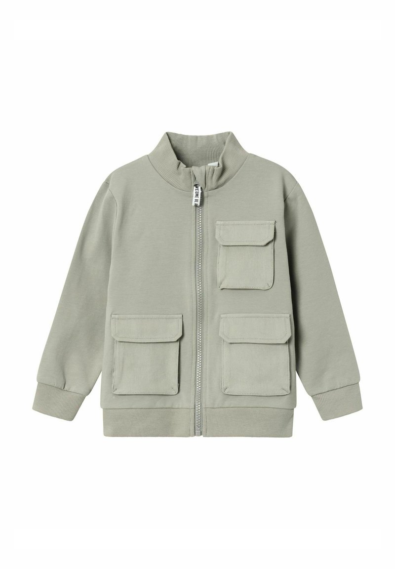 Chaqueta de cremallera verde claro con cuello alto, que cuenta con dos bolsillos en el pecho y puños acanalados. Fabricada con un tejido suave y texturizado.