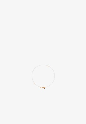 Beli pleteni zapestnica v beli barvi z zlatimi detajli, ki ima majhen okrasni sponko. Gladka tekstura, lahka zasnova in prilagodljiva oblika.