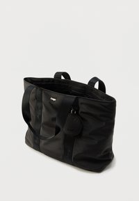 Μαύρη τσάντα ώμου από λείο νάιλον. Διαθέτει δύο ανθεκτικές χειρολαβές, κλείσιμο με φερμουάρ και προσαρτημένη στρογγυλή θήκη με λογότυπο της εταιρείας.