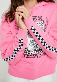 Sudadera rosa hecha de una mezcla de algodón, con estampado gráfico y detalles a cuadros en las mangas. Los puños y el dobladillo acanalados ofrecen textura.