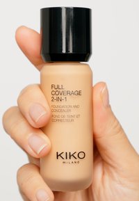 Fond de teint et correcteur 2 en 1 KIKO Milano dans un flacon beige avec un capuchon noir à vis. Texte affiché en évidence sur le flacon. Texture mate.