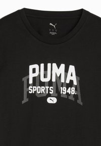 Sort bomulds T-shirt med rund udsnit. Har fed hvid tekst "PUMA SPORTS 1948" og logo, med en tekstureret grå baggrund.