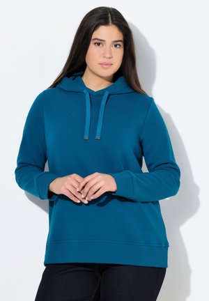 Sweat à capuche turquoise avec cordon de serrage, manches et ourlet côtelés. Texture douce, coupe décontractée, associé à un jean noir. Fond uni.