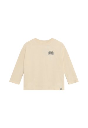 Camiseta beige de manga larga con cuello redondo, con un pequeño logo de texto negro en el pecho izquierdo y una pequeña etiqueta cerca del dobladillo inferior.