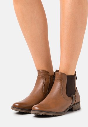 Bottines en cuir marron avec des panneaux élastiques sur les côtés, finition texturée, accents de couture et un faible talon. Design léger avec une forme classique.